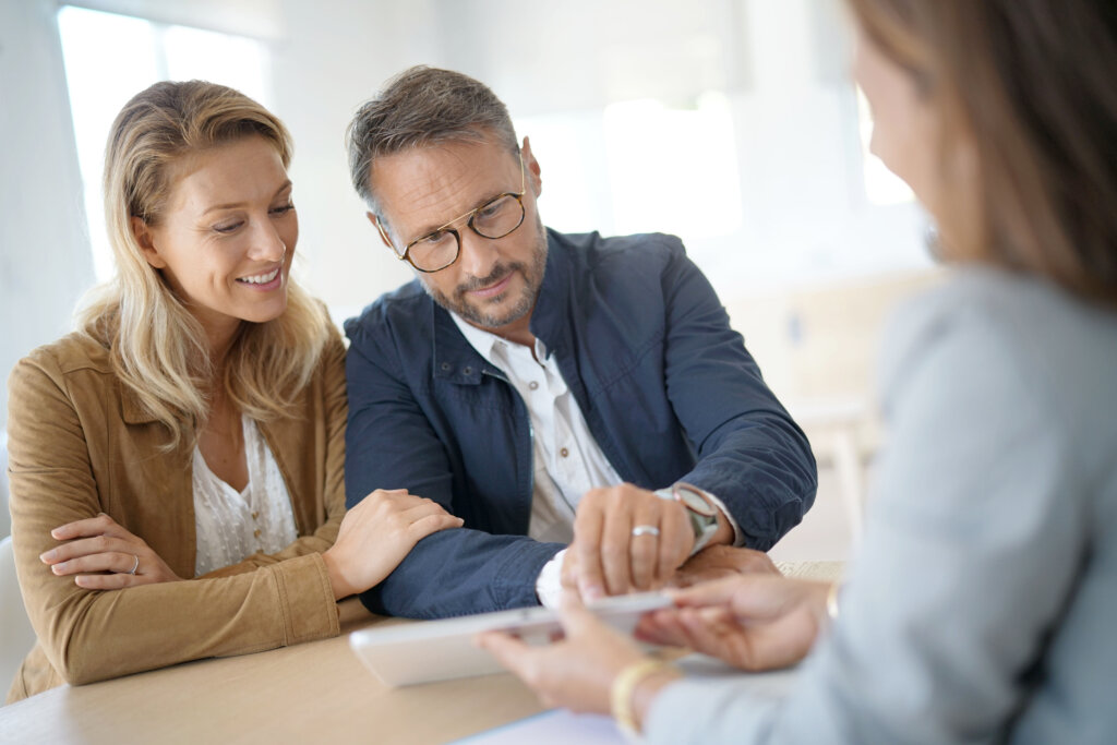 Mature couple meeting real-estate agent in office
