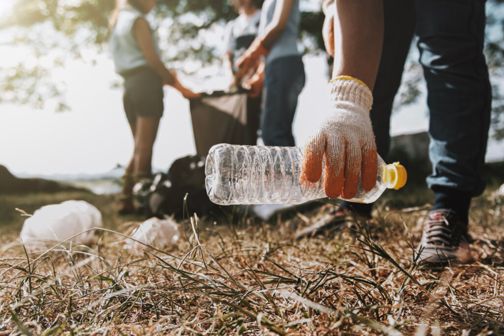 people picking up garbage and putting it in plastic black bag for cleaning