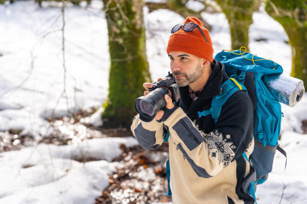 Photographer enjoying taking photos in winter in a snowy forest
