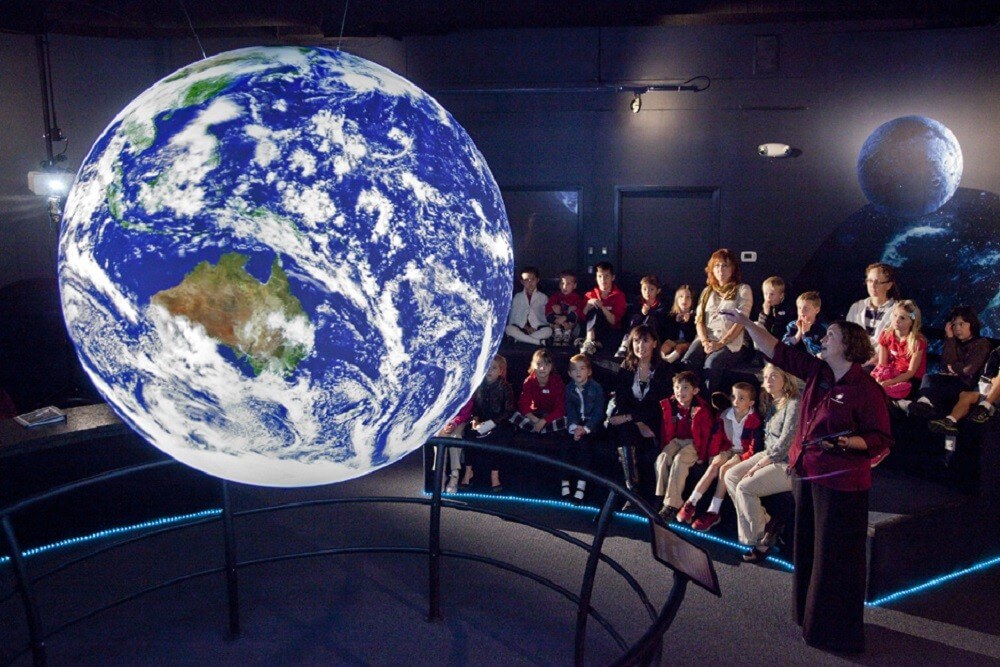 group of people learning at a Space Foundation Discovery Center exhibit