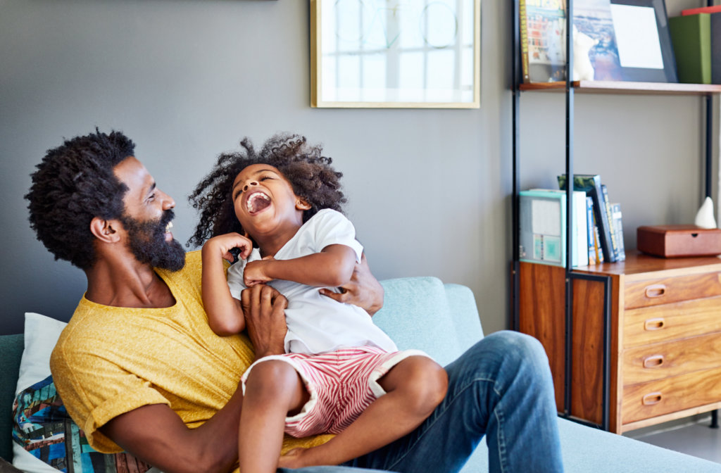 a father and daughter laughing at home together